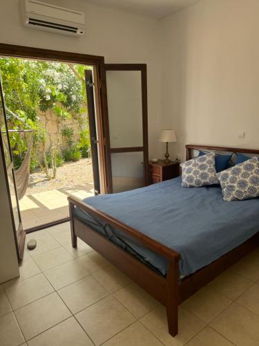 a bedroom with a bed and a sliding glass door at Villa Europa Ravdoucha Private Pool and Amazing View in Ravdhoúkha