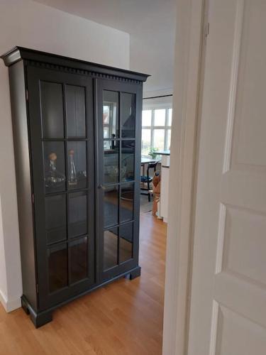 a black cabinet with glass doors in a room at Lovely south-facing patio with grill in Hönö