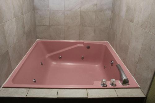 El baño incluye bañera rosa con lavamanos. en Quality Inn - Conway, en Conway