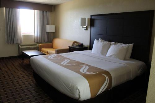 una habitación de hotel con una cama grande y una silla en Quality Inn - Conway, en Conway
