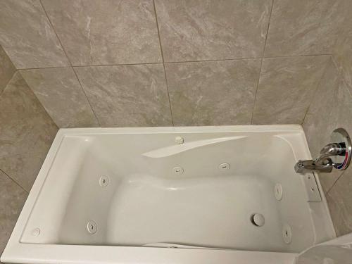 a white bath tub in a bathroom with a tile wall at The Inn at Baechtel Creek in Willits