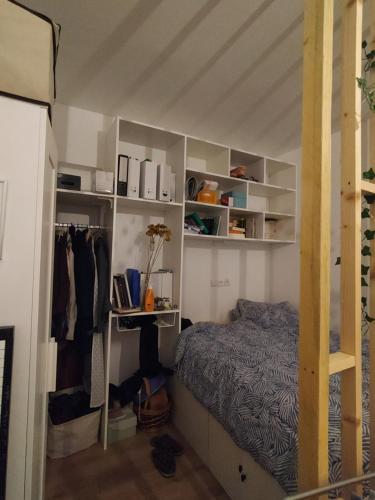 - une chambre avec un lit et des étagères blanches dans l'établissement Cosy apartment in Paris, à Paris