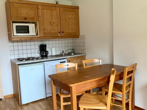 a kitchen with a table and chairs and a microwave at Les granges d'Arvieux vue sur le Queyras in Arvieux