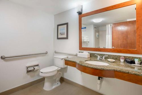 a bathroom with a toilet and a sink and a mirror at Surf and Sand Fernandina Beach at Amelia Island, an Ascend Collection Hotel in Fernandina Beach
