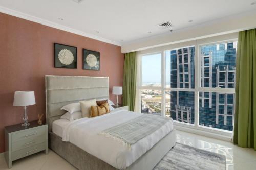 a bedroom with a large bed and a large window at GuestReady - Exclusive Comforts near Burj Khalifa in Dubai