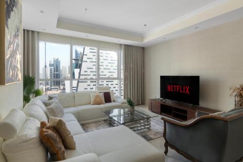 a living room with a white couch and a television at GuestReady - Exclusive Comforts near Burj Khalifa in Dubai