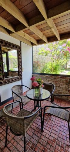 un patio avec une table et des chaises sur un porche dans l'établissement La Verrière, à Cherbourg en Cotentin