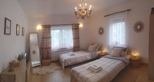 Łącko的住宿－Gościniec pod Skółką，一间卧室配有两张床和吊灯。