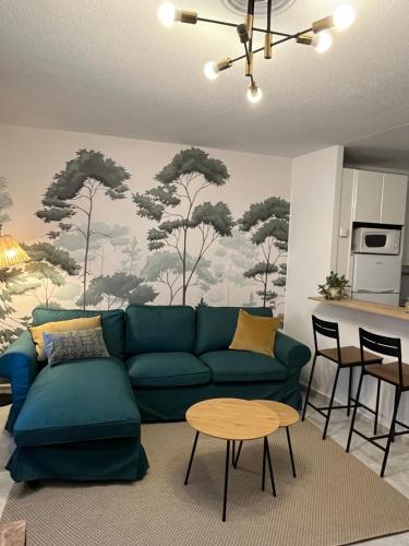 Una sala de estar con un sofá verde y una mesa. en Encantador apartamento Enlosado de Balborraz, en Zamora