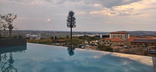 a large swimming pool with a view of a city at Cosy Ellipse 2012 Waterfall Midrand in Midrand