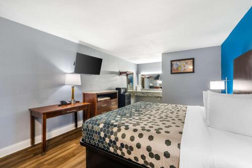 a small hotel room with a bed and a desk at Econo Lodge Inn & Suites Virginia Beach - Norfolk in Virginia Beach