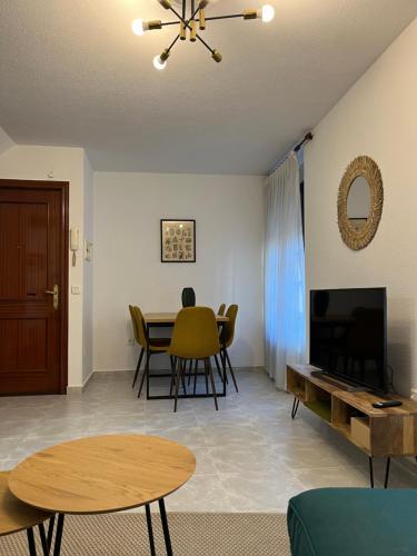 Una sala de estar con una mesa y un televisor. en Encantador apartamento Enlosado de Balborraz, en Zamora