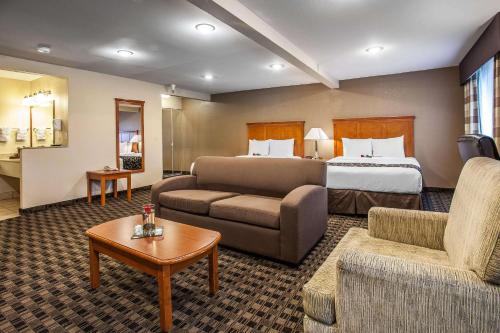 a hotel room with a bed and a couch at Clarion Inn Renton-Seattle in Renton