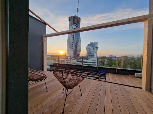 a balcony with two chairs and a view of a building at Luxury Penthouse Rzeszów in Rzeszów
