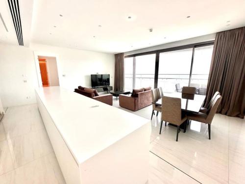 a white living room with a table and chairs at Del Mar Beachfront 3 Bedroom 'A' Residence in Limassol