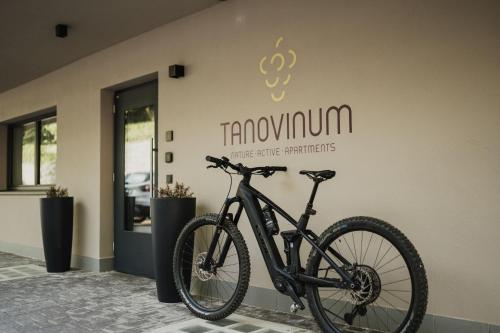 a black bike parked in front of a building at TANOVINUM Apartments in Villandro