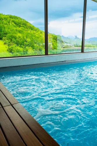 a swimming pool in a building with blue water at Aura Relais in Urbino