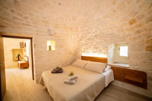 um quarto com uma cama numa parede de pedra em Trulli Balè em Locorotondo