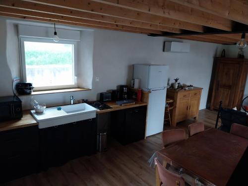 une cuisine avec un évier et un réfrigérateur dans l'établissement Le Ty Douar, à Coëtmieux