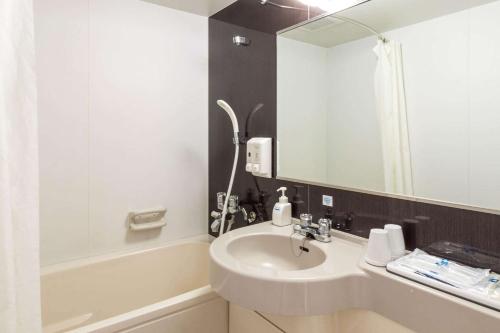 a bathroom with a sink and a mirror at Comfort Hotel Tomakomai in Tomakomai