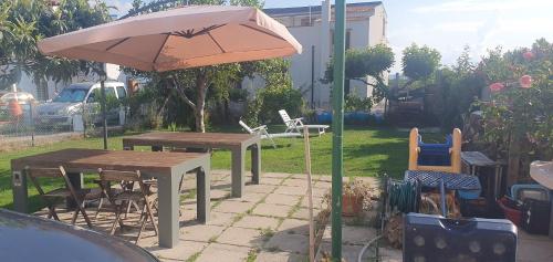 una sombrilla, mesas y sillas en un patio trasero en Simpatico appartamento autonomo sul mare en Termoli