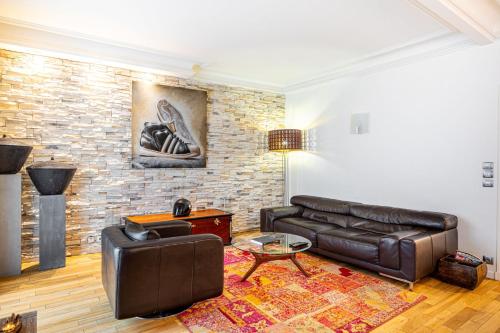 - un salon avec un canapé en cuir et un mur en briques dans l'établissement GuestReady - Modern Delight near Attractions, à Paris