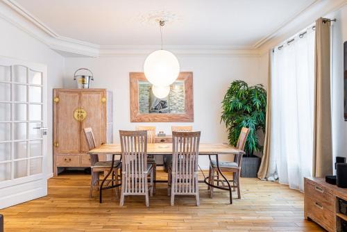 une salle à manger avec une table et des chaises en bois dans l'établissement GuestReady - Modern Delight near Attractions, à Paris