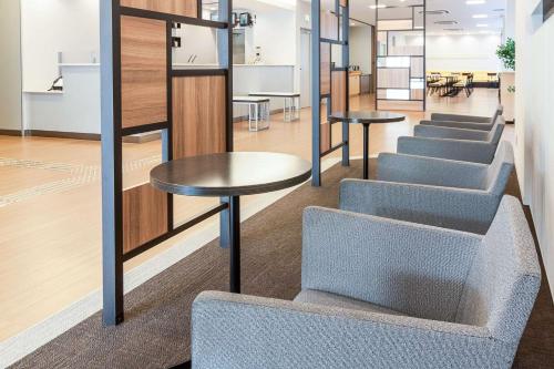 a row of tables and stools in a room at Comfort Hotel Shin Yamaguchi in Yamaguchi