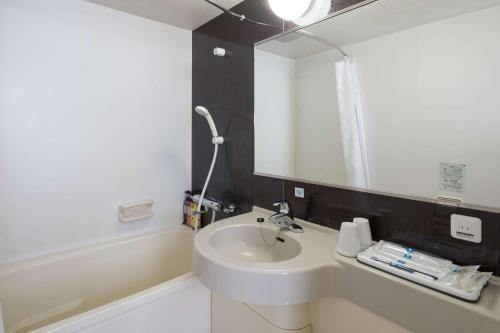 uma casa de banho com um lavatório e um espelho em Comfort Hotel Kumamoto Shinshigai em Kumamoto