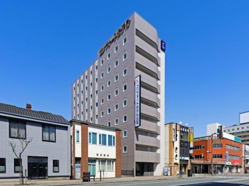 a tall building on a city street with buildings at Comfort Hotel Kitami in Kitami