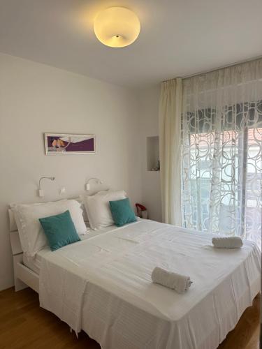 1 dormitorio con 1 cama blanca grande y ventana en Apartment Breze, en Split