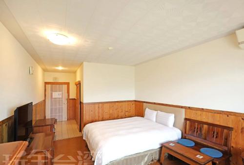 a bedroom with a bed and a desk and a television at 清境 百里莊園 Baili Manor Cing Jing in Renai