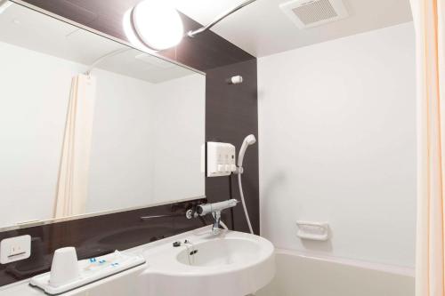 a bathroom with a sink and a mirror at Comfort Hotel Wakayama in Wakayama