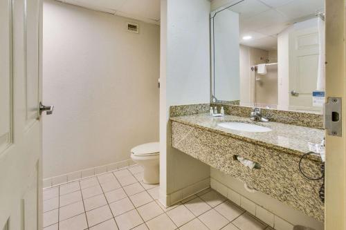 a bathroom with a sink and a toilet and a mirror at Quality Inn Fort Campbell-Oak Grove in Oak Grove