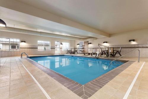 Country Inn & Suites by Radisson, St Peters, MO في سانت بيترز: مسبح كبير مع ماء أزرق في غرفة الفندق