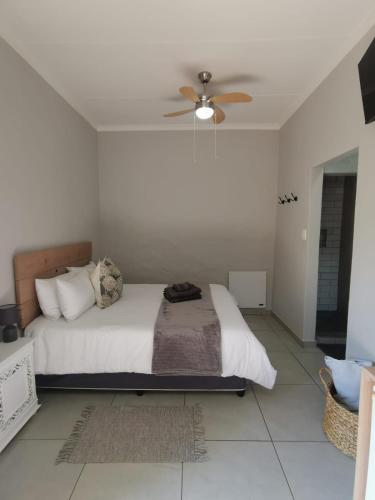 a bedroom with a bed and a ceiling fan at Stay@Opstal in Pretoria