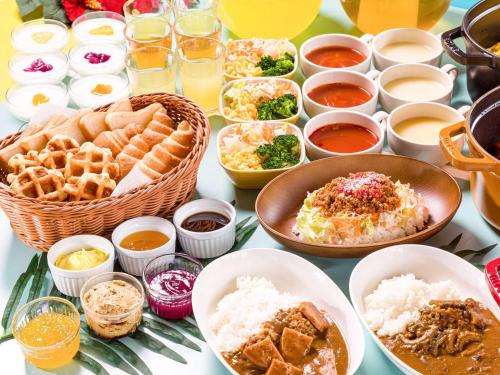 a table with various dishes of food on it at Comfort Hotel Ishigaki Island in Ishigaki Island