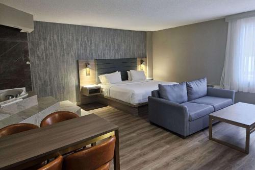 pokój hotelowy z łóżkiem i kanapą w obiekcie Radisson Hotel Montreal Airport w mieście Ville Saint Laurent