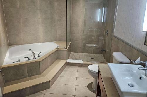 uma casa de banho com uma banheira, um WC e um lavatório. em Radisson Hotel Montreal Airport em Ville Saint Laurent
