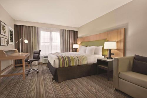 Pokój hotelowy z łóżkiem, biurkiem i krzesłem w obiekcie Country Inn & Suites by Radisson, Wytheville, VA w mieście Wytheville