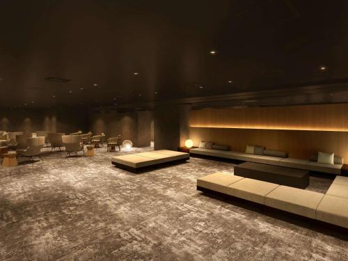 Großes Zimmer mit Sofas, Tischen und Stühlen in der Unterkunft Grand Mercure Wakayama Minabe Resort & Spa in Minabe