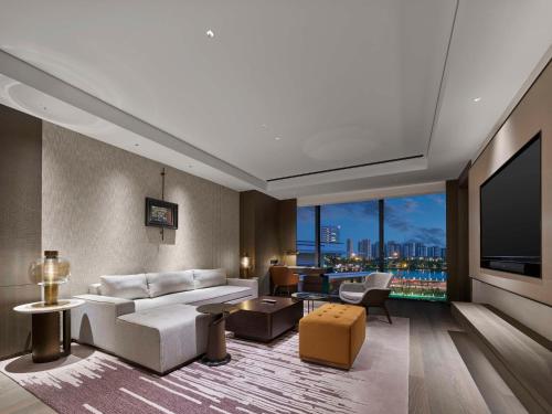 Una sala de estar con un sofá blanco y una ventana grande. en Hilton Changshu, en Changshu
