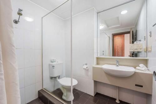 a bathroom with a toilet and a sink and a mirror at Comfort Resort Waters Edge in Port Macquarie