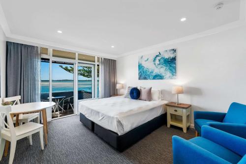 um quarto de hotel com uma cama, uma mesa e cadeiras em Comfort Resort Waters Edge em Port Macquarie