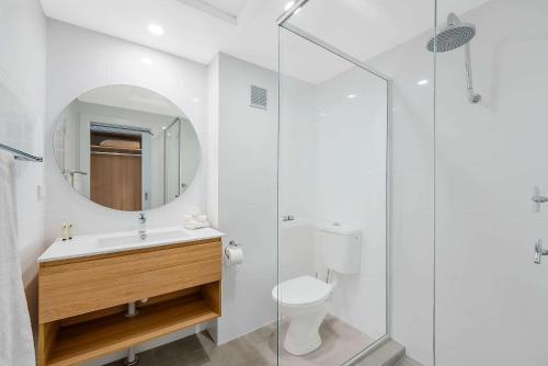 a bathroom with a toilet and a glass shower at Comfort Resort Waters Edge in Port Macquarie