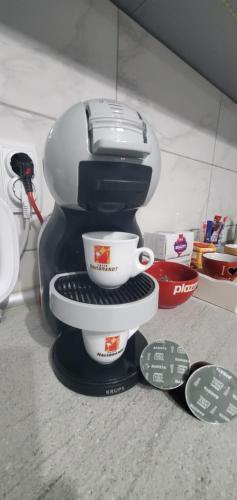 a coffee maker with two cups on a shelf at Antic Apartment in Požarevac