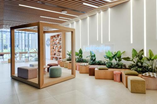 First Class 1BR Apartment in Dubai Hills - next to Dubai Hills Mall في دبي: لوبي مع صف من الكراسي والنباتات