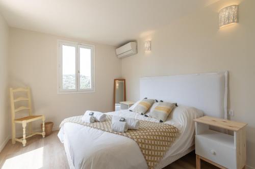 une chambre blanche avec un lit et une fenêtre dans l'établissement Villa Oleander, à Valbonne