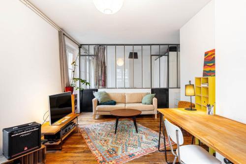 un salon avec un canapé et une table dans l'établissement GuestReady - Séjour Charmant dans le 18ème, à Paris