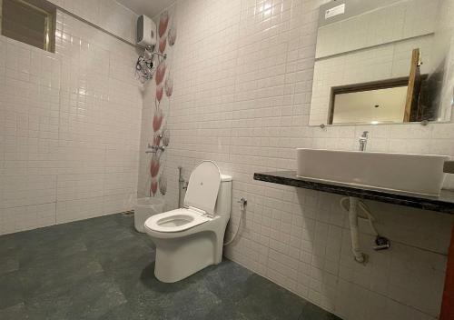 a white bathroom with a toilet and a sink at Baga Vista in Baga